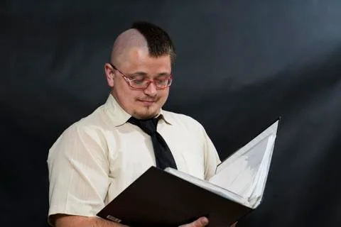 Punk stands with a working folder. White shirt and red tie. Facial expression of Foto stock