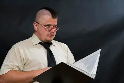 Punk stands with a working folder. White shirt and red tie. The person is turned 스톡 사진