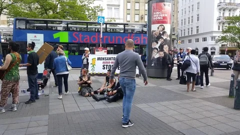 Punks sit on the ground next to banner against Monsanto, Hamburg, Germany Vídeos de archivo 76286573