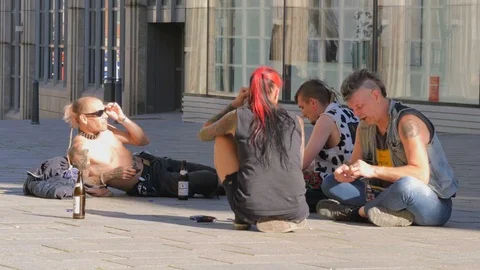 Punks sit on the ground on pedestrianized street in Lubeck, Germany. Subculture. Stock Footage 76365334