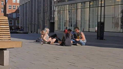 Punks sit on the ground on pedestrianized street in Lubeck, Germany. 스톡 동영상 76487560