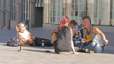Punks sit on the ground on pedestrianized street in Lubeck, Germany. Vídeos de archivo 76493118