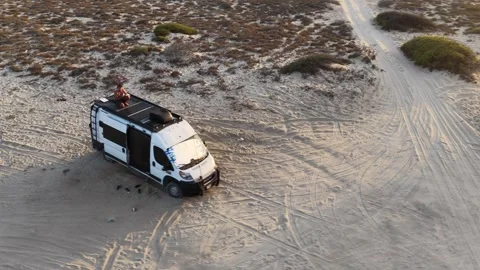 Punta Arena camper van life, man sits on roof at sunset, La Ventana, Mexico Stock Footage 346486447
