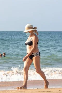 Punta Umbria, Huelva, Spain - August 7, 2020: Woman walking by the beach wearing Stock Photos