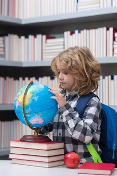 Pupil looking at globe in library at the elementary school. Back to school Stock Photos