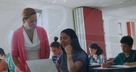 Pupil raising hand asking question in class, teacher leaning viewing laptop and Stock Footage 329114961