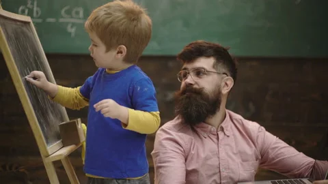 Pupil with teacher at school. Side view father and son learn arithmetic. Daddy Stock Footage 111818073