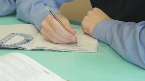 Pupil writes text in a notebook indoors Stock Footage 71416425