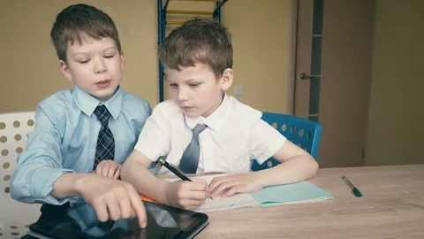 Pupils do homework, write numbers in notebooks, one of them explains what needs Video stock 105097956