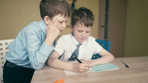 Pupils do homework, write numbers in notebooks, help each other, on the tables Stock Footage 105098208