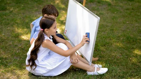 Pupils drawing on a white board outdoors Video stock 130051153