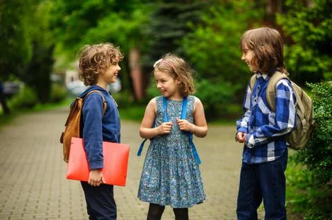 Pupils of elementary school about something cheerfully talk on the schoolyard Stock Photos