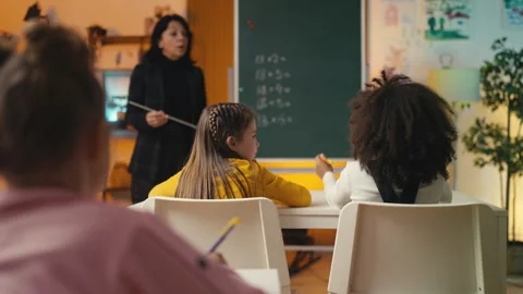 Pupils listen as the math teacher explains the material near the chalkboard Stock Footage 298019570