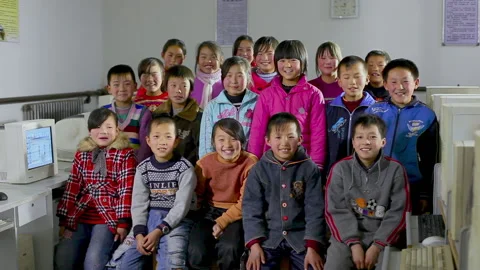 Pupils from a poor elementary school take a group photo in the classroom, china Stock Footage 143897301