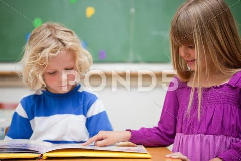 Pupils reading a book Stock Photos