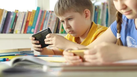 Pupils using mobile phone at the elementary school.Students using a mobile phone Stock Footage 87611646