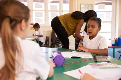 Pupils Working At Desks In Elementary School Classroom Stock Photos