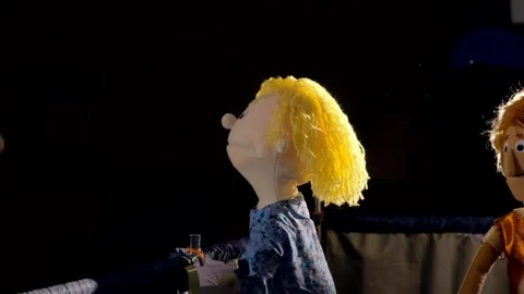 Puppet characters performing on indoor stage with dark curtain backdrop 動画素材 340886758