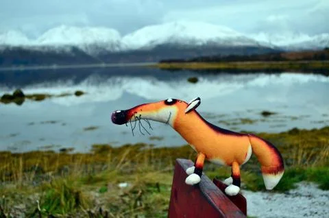 Puppet fox is resting in the picnic area on the bank of the mountain lake Stock Photos