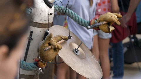 A puppet made of recycled materials playing with cymbals displayed on the Stock Footage 122975326