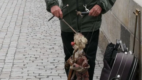 The puppet master directs the doll on the street which plays a musical Stock Footage 82063156