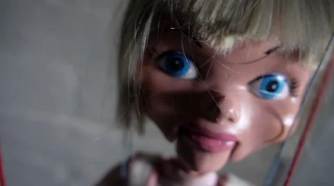 Puppet swinging on strings toward camera Stock Footage 55776443