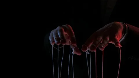 Puppeteer manipulating and pulling strings of marionettes. Male hands close up Stock Footage 146639053