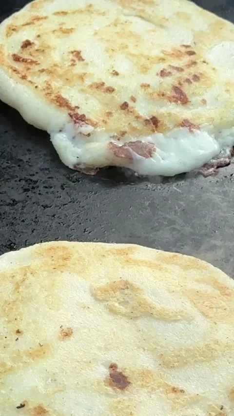 Pupusa Oozing Cheese on Griddle Surface Stock Footage 323876208