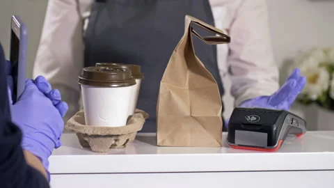Purchase of coffee and snacks to go. Seller and buyer in protective gloves. Fast Stock Footage 149869213