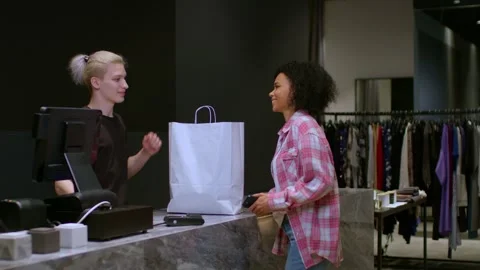 The purchase has been completed and a young black woman takes bag with new Stock Footage 262627626