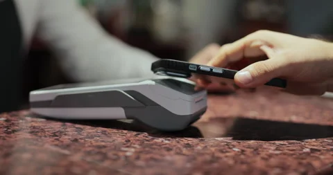 Purchase by smartphone on card reader. Pos-terminal in hand of waiter worker Stock Footage 319019756