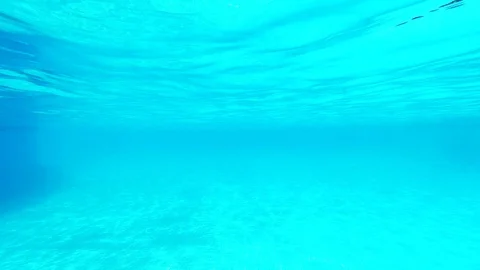 Pure blue water in the pool with light reflections. View from under water on Stock Footage 112663911