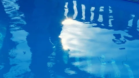 Pure blue water in the pool with light reflections of a girl silhouette in sunny Stock Footage 114973372