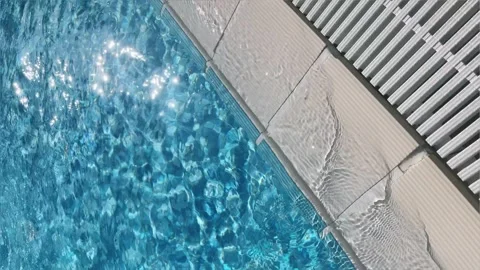 Pure blue water in the pool with light reflections. Slow motion. 4k vertical Stock Footage 243168097