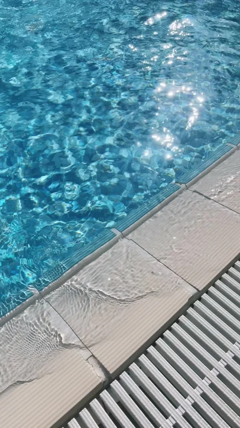 Pure blue water in the pool with light reflections. Slow motion. 4k vertical Stock Footage 282360952