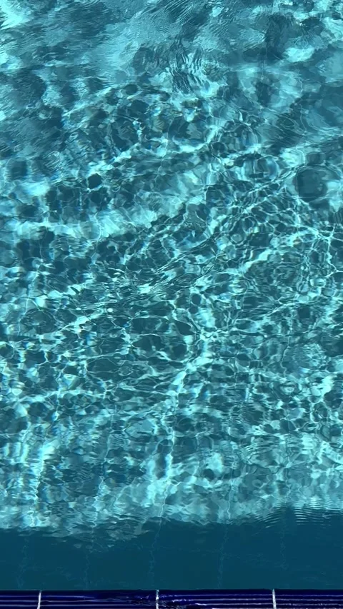 Pure blue water in the pool with light reflections. Slow motion. Vertical Stock Footage 346720488