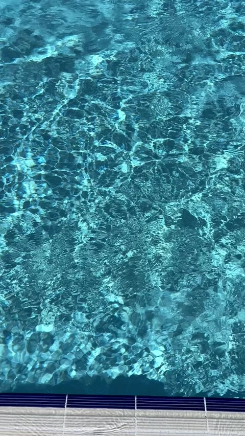 Pure blue water in the pool with light reflections. Slow motion. Vertical Stock Footage 346720963