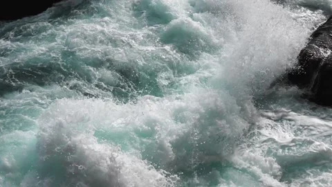 Pure bright turquoise waves break into white foam on the coastal cliffs and seet Stock Footage 238825534