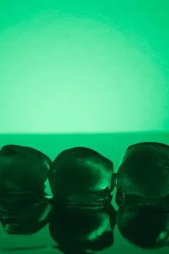 Pure clean Ice Cubes Melting On Mirror Surface In Neon Green Light Still Life Stock Photos