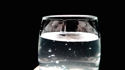Pure clear water being poured in transparent glass in slow motion 動画素材 342806834
