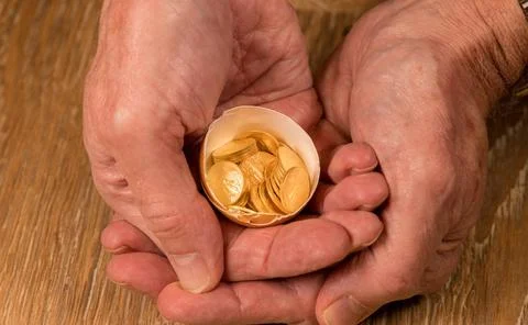Pure gold coins in egg shell illustrating nest egg Senior man s hand holdi... Stock Photos