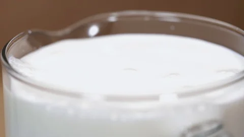 Pure milk in glass jar in string, making splashes Stock Footage 94830566