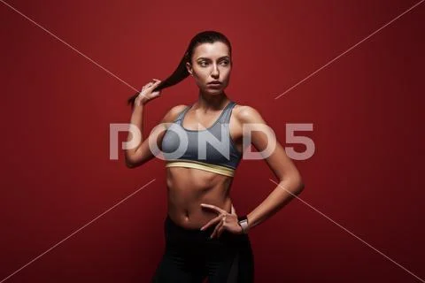 Pure perfection. Sportswoman standing over red background Stock Photos