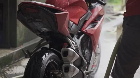 The pure red motorcycle body is close. The stage of motorcycle washing is hosing Stock Footage 237274863