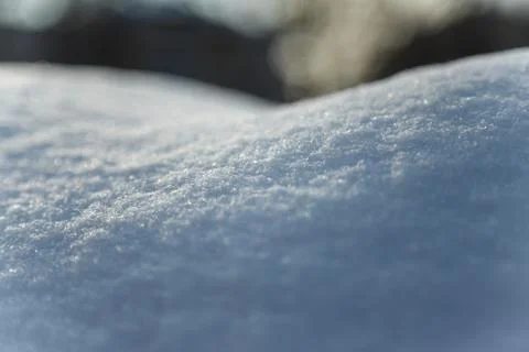 Pure snowgrift surface texture on blurry background at sunny day Stock Photos