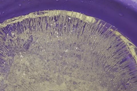 Pure transparent rectangular ice block with air bubbles on violet Stock Photos