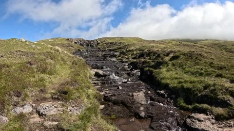 Pure water mountain stream cascading down green rocky hill in Faroe Islands Stock Footage 337460065