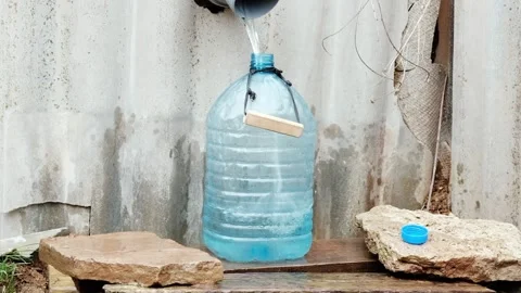 Pure water from a wild source is poured into an empty plastic bottle. Stock Footage 297607333