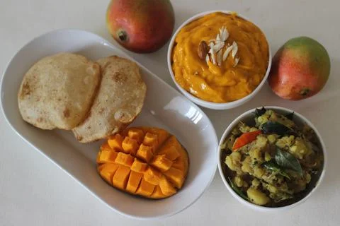 Puri served with mango pulp and potato masala. Locally known as puri masala a Stock Photos