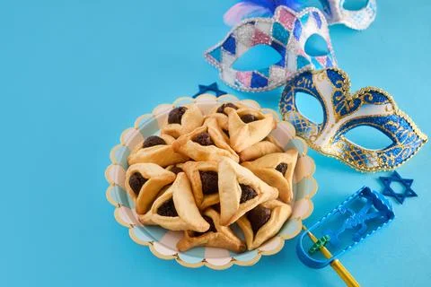 Purim celebration objects including hamantaschen, masks, and gragger Stock Photos